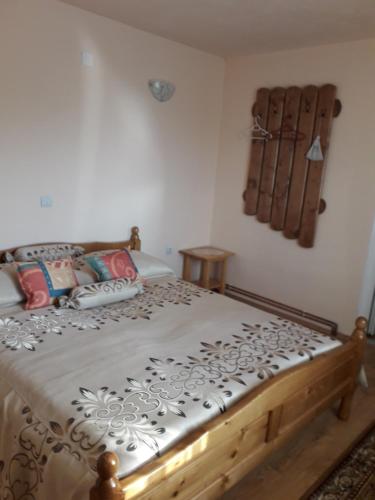 1 dormitorio con 1 cama con marco de madera en Casa cu Muscate, en Câmpeni
