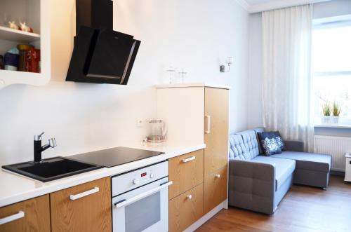 a kitchen with a sink and a couch in a room at Gagarina 33 - studio by Homeprime in Warsaw