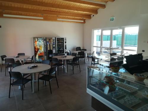 jadalnia ze stołami i krzesłami oraz oknem w obiekcie Camping Verona Village w Weronie