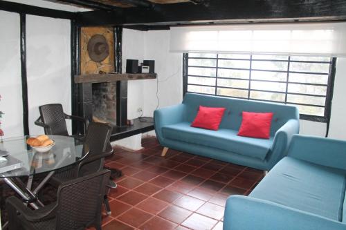 a living room with a blue couch and red pillows at Chalet Guatavita - Tominé. La Casa Amarilla in Guatavita