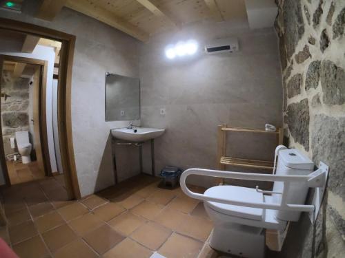 a bathroom with a white toilet and a sink at Albergue A Salazon in Villanueva de Arosa