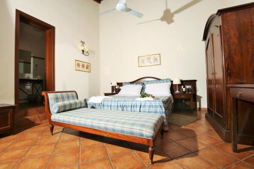 a bedroom with a bed and a chair at Le Case Del Merlo Turismo Rurale in Milo