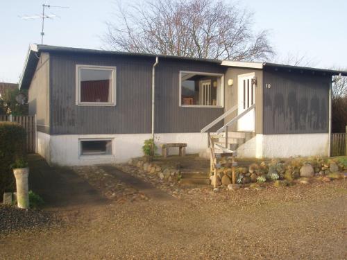 a small house with a fence next to it at "Alléhuset" in Roslev