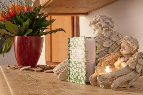 a table with a statue and a vase with flowers at Pension Anna in Sankt Leonhard im Pitztal