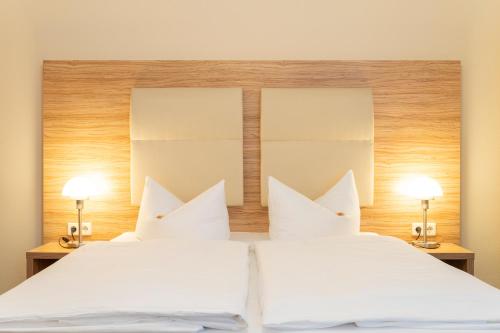 a bedroom with two white beds and two lamps at Palais am Kleistpark in Frankfurt/Oder