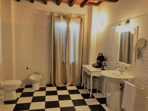 a bathroom with two sinks and a toilet and a shower at Il Contado -room and breakfast- in Castelfranco Emilia