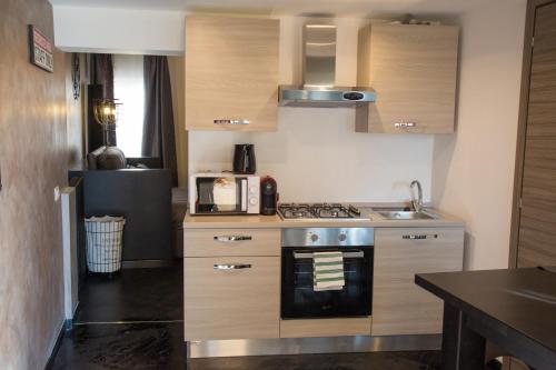 una cucina con armadi in legno e piano cottura. di Industrial Apartment Near Duomo a Milano