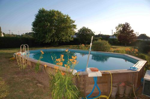 a swimming pool with a hose in a yard at Chambres d'Hôtes Les Coquelicots in Francueil