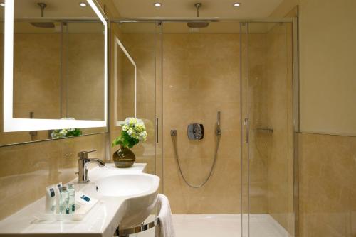 a bathroom with a sink and a shower at UNAHOTELS Century Milano in Milan