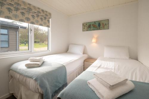 two twin beds in a room with a window at Horizon Lodge in Sizewell