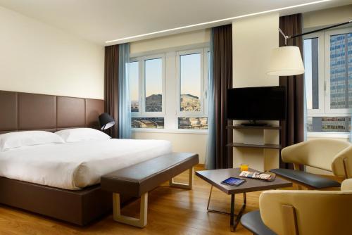 pokój hotelowy z łóżkiem i telewizorem w obiekcie UNA HOTELS Century Milano w Mediolanie