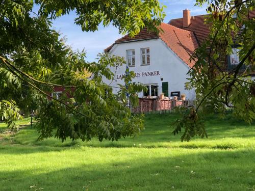 a white house with a tree in front of it at Landhaus Panker in Panker