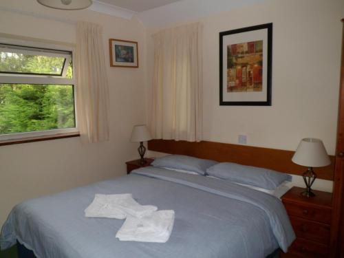 a bedroom with a bed with two towels on it at Carlton Lodge in Cambridge
