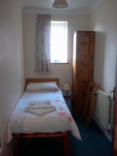a small bedroom with a bed and a window at Carlton Lodge in Cambridge