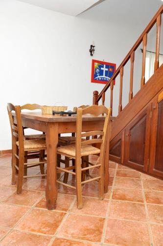 a wooden table and chairs in a room with a staircase at Hydra Erato in Hydra