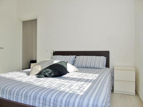 a bed with a blue and white striped sheets and pillows at Fiori Sul Mare in Tellaro