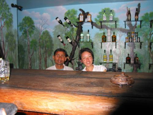a man and a woman sitting at a bar at Rhino Lodge Bardia Pvt Ltd in Bhurkīā