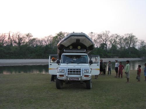 a white truck with a boat on the top of it at Rhino Lodge Bardia Pvt Ltd in Bhurkīā