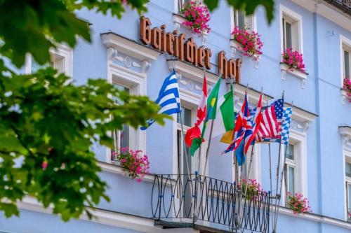 a blue building with flags on a balcony at Hotel Bairischer Hof in Marktredwitz