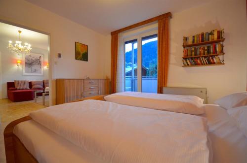 une chambre avec deux lits blancs et une fenêtre dans l'établissement Spacious 2 bedroom apartment Zell-am-See town center, à Zell am See
