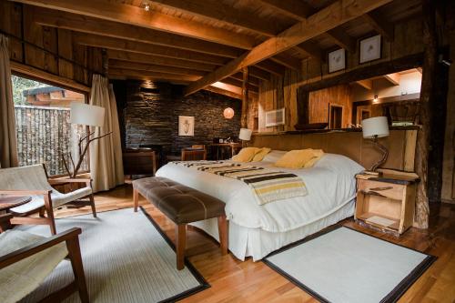a bedroom with a large bed in a room with wooden walls at Huilo Huilo Nawelpi Lodge in Huilo Huilo