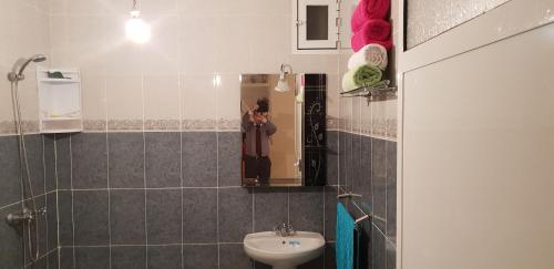 una persona que toma una foto en un espejo de baño en Appartement de luxe centre ville les "Dunes d'Or", en Oujda