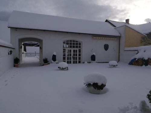 a white house with snow on the ground at Pension Šejko in Horní Planá