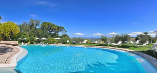 uma piscina com cadeiras e guarda-sóis num resort em Castello Di Monterado em Monterado