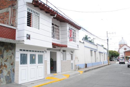 ein weißes Gebäude an der Straßenseite in der Unterkunft Hotel Ciudad Señora Buga in Buga