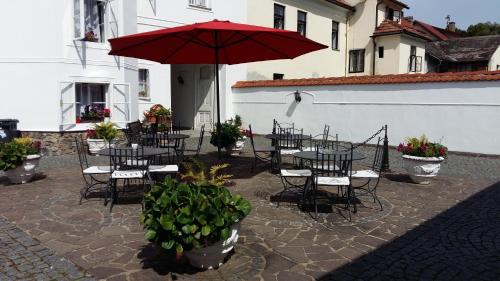 a patio with tables and chairs and an umbrella at Pension Šejko in Horní Planá