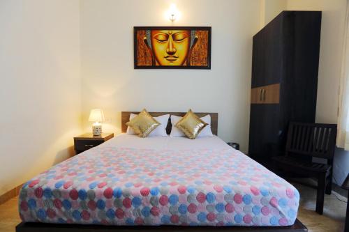 a bedroom with a large bed with a mask on the wall at Runway Residency at Pitampura in New Delhi