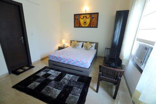 a small bedroom with a bed and a chair at Runway Residency at Pitampura in New Delhi