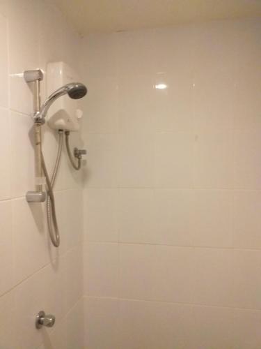 y baño con ducha con cabezal de ducha. en Zenith Inn & Resto Bar en Anda