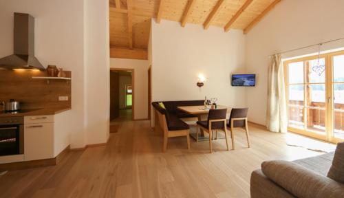 - une cuisine et une salle à manger avec une table et des chaises dans l'établissement Dürnberggut, à Sankt Martin bei Lofer