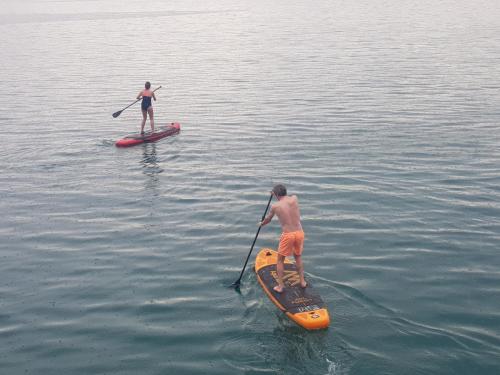 two men on paddle boards in the water at Beach Apartments in Tivat