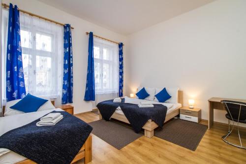 een slaapkamer met 2 bedden en blauwe gordijnen bij Silver Apartments in Kutná Hora