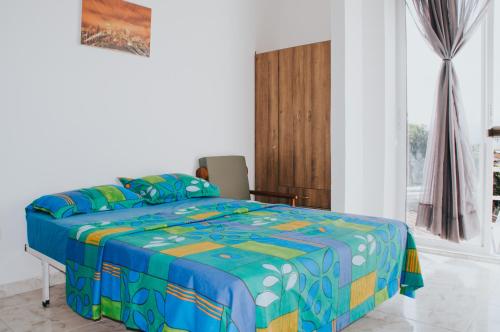 a bedroom with a bed with a colorful comforter at Bello Apt Buga con Bella vista y refrescante Brisa in Buga