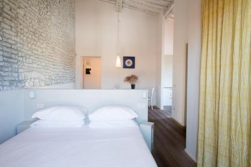 a bedroom with a white bed and a brick wall at Villa Aruch in Florence