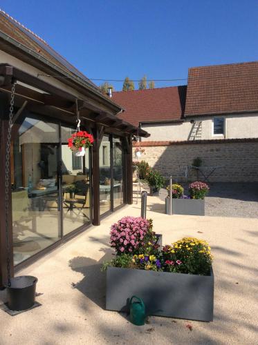 a patio with a bunch of flowers in front of a house at Maison d’izier in Izier