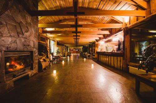 a large room with a fireplace and a stone wall at Huilo Huilo Nothofagus Hotel & Spa in Huilo Huilo