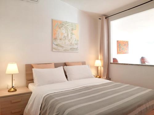 a bedroom with a bed with white sheets and a window at The Terrace in Vernazza