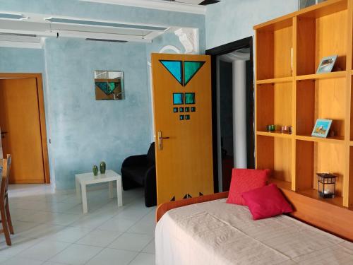 a bedroom with a bed and a yellow door at Webus Apartments in Praia a Mare