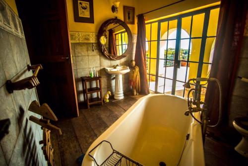 a bathroom with a bath tub and a sink at One Minute South Villa in Bulago Island