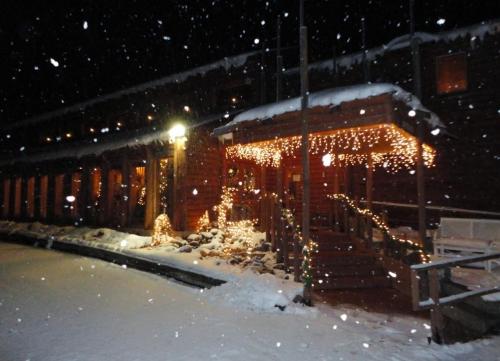 a building covered in christmas lights in the snow at The Lodge at Lolo Hot Springs in Lolo