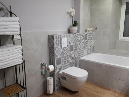 a bathroom with a tub and a toilet and a sink at Guesthouse Juric in Skradin