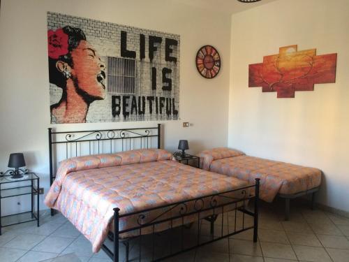 Casa Vacanze La Stazione في براتشيانو: غرفة نوم بسريرين وساعة على الحائط
