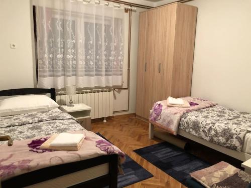 a room with two beds and a window at Apartment Dada in Bjelovar