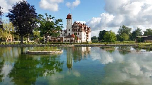 a large building with a reflection in a lake at Historisches Gebäude " Rentmeisteramt" Basedow in Basedow