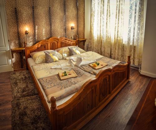 a large wooden bed with two plates of food on it at Guesthouse Ilona in Veľký Kamenec