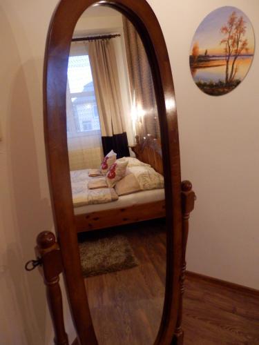 a mirror with a bed in a room at Guesthouse Ilona in Veľký Kamenec